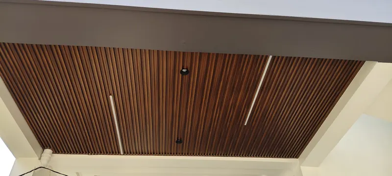 Wood-effect slatted ceiling with recessed lights and LED strips over an outdoor area