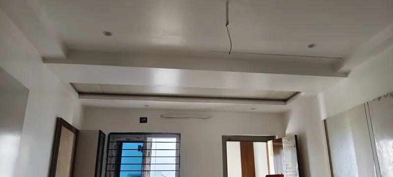 Gypsum false ceiling with stepped edges and recessed lights in a room