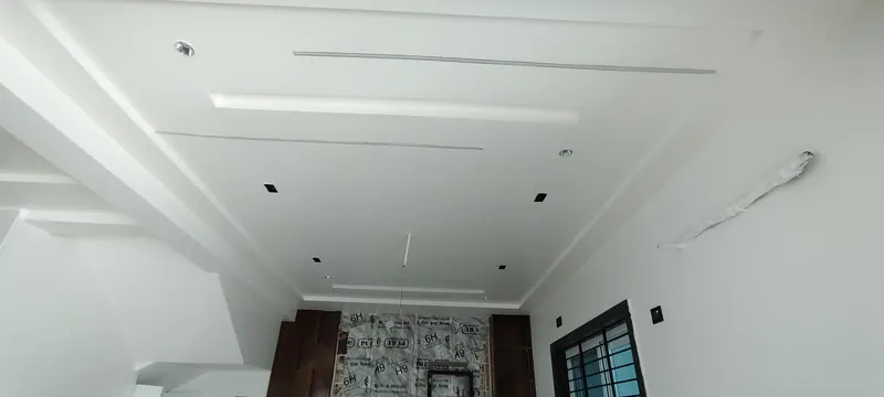 Gypsum false ceiling with recessed lights and light slots in a room