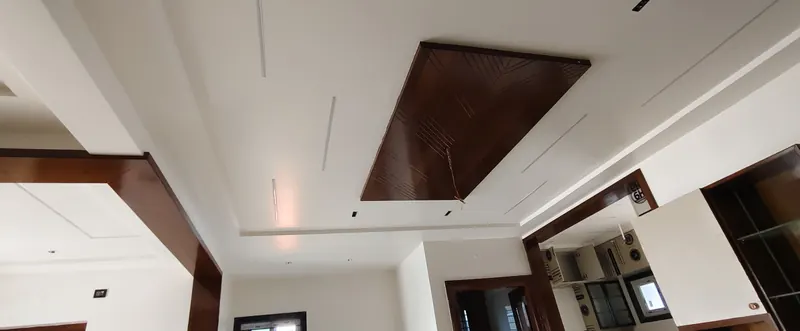 Gypsum false ceiling with a wood-finish panel and light slots