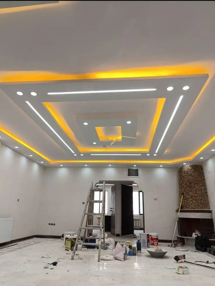 Gypsum ceiling with layered cove lighting and white LED lines in a large hall
