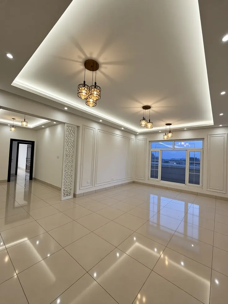 Layered gypsum ceiling with soft cove lighting and pendant lights in a large hall