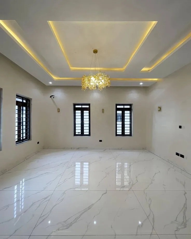 Rectangular layered gypsum ceiling with warm cove lighting and a chandelier