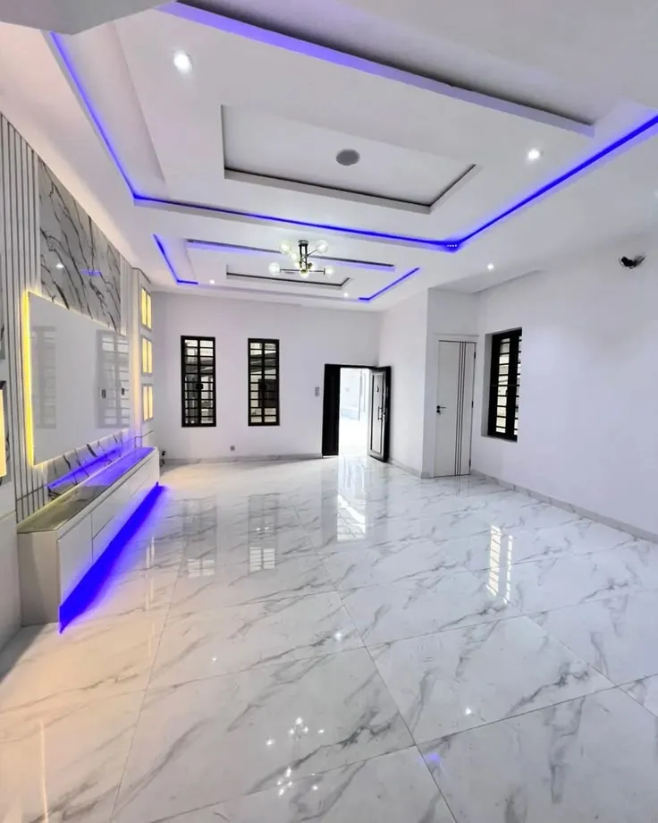 Gypsum ceiling with blue cove lighting and a matching lit TV wall unit
