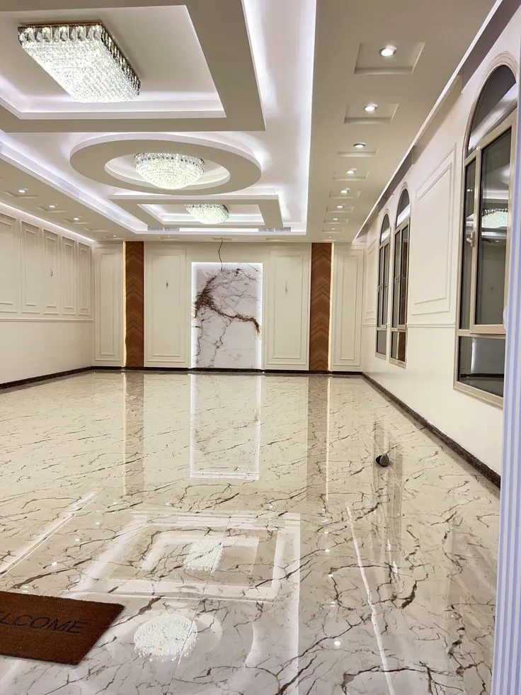 Gypsum ceiling with circular layers and a crystal light fitting in a large hall