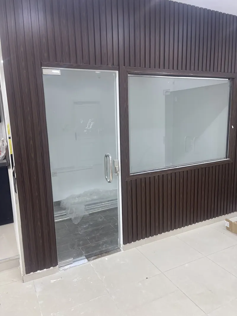 Glass door and window set in a dark fluted partition wall