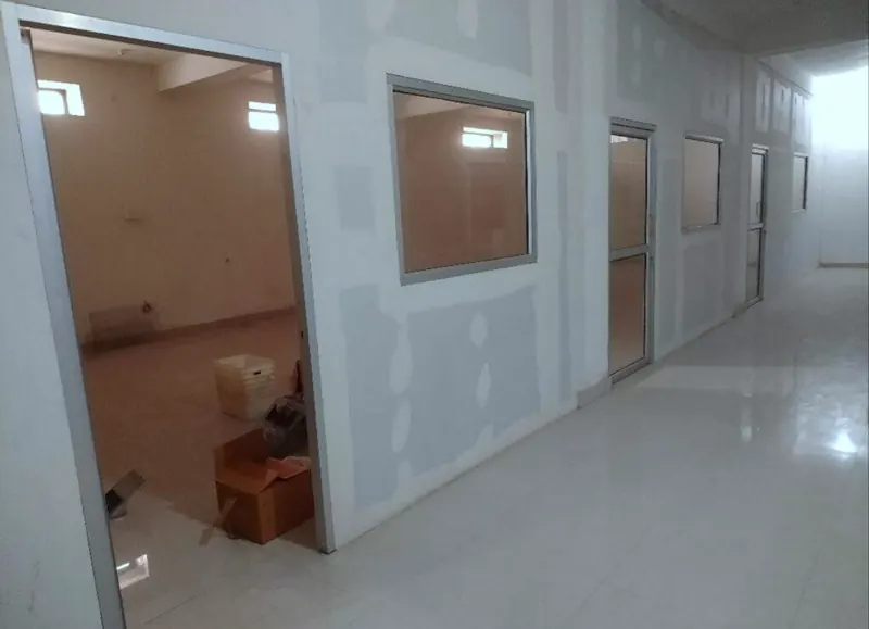 Corridor with gypsum partition walls and aluminium-framed windows and doors before final finishing