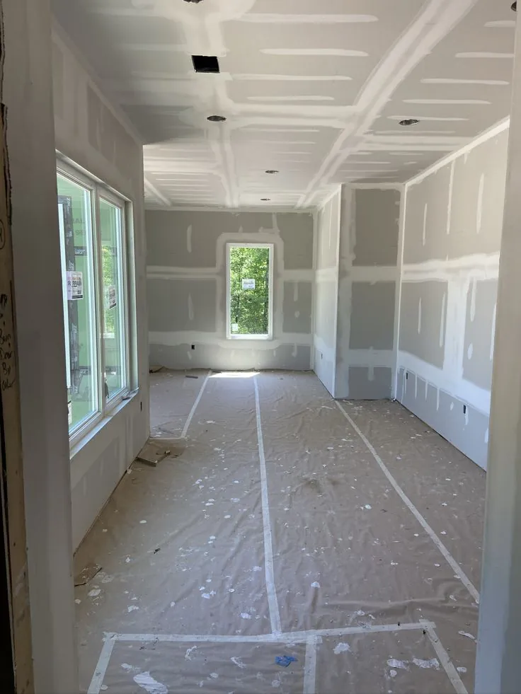 Room enclosed with new gypsum board walls and ceiling during finishing