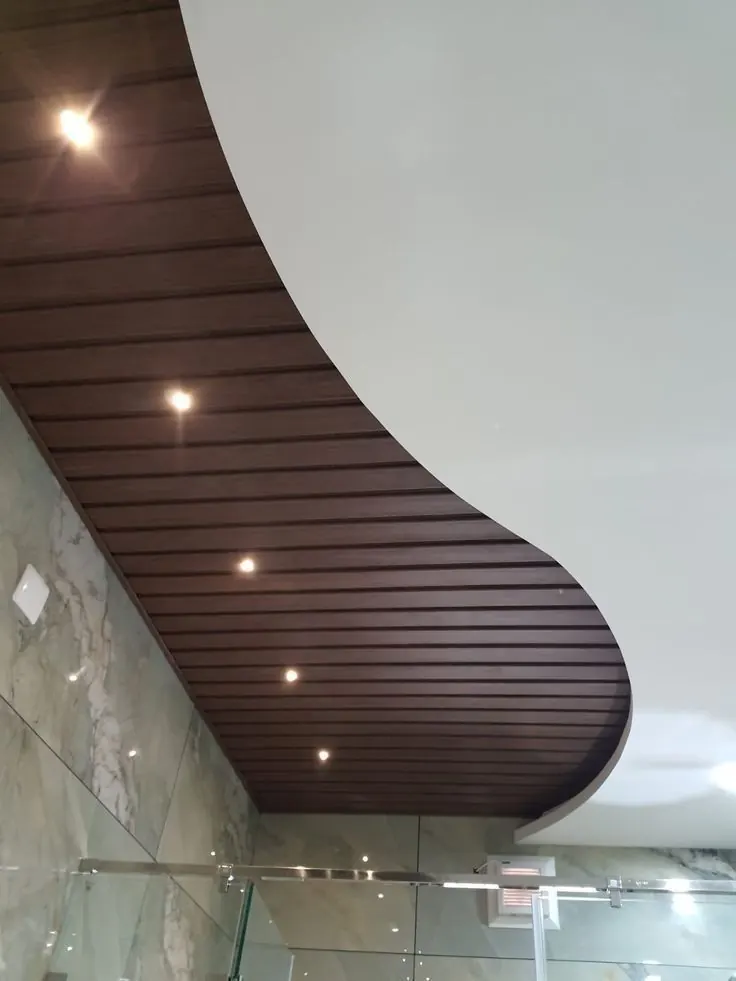 Curved wood-effect slatted ceiling with recessed lights