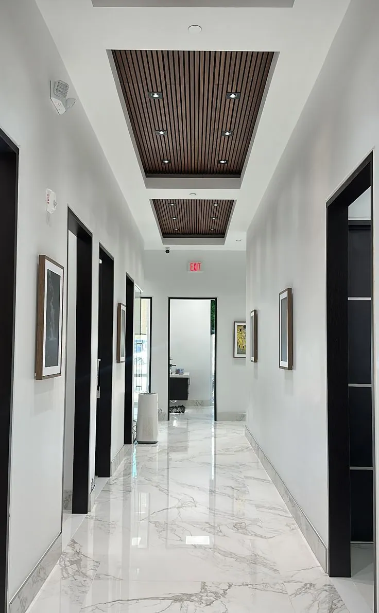 Corridor with wood-effect slatted ceiling panels and recessed lights