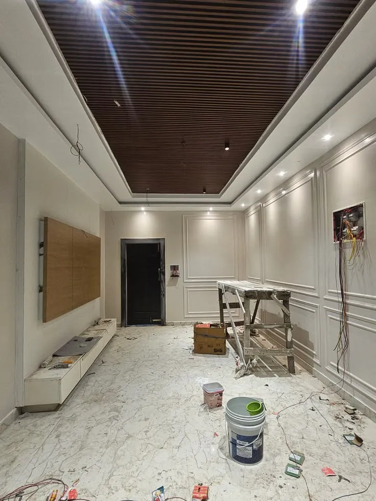 Wood-effect slatted ceiling panel with recessed lights in a room during finishing