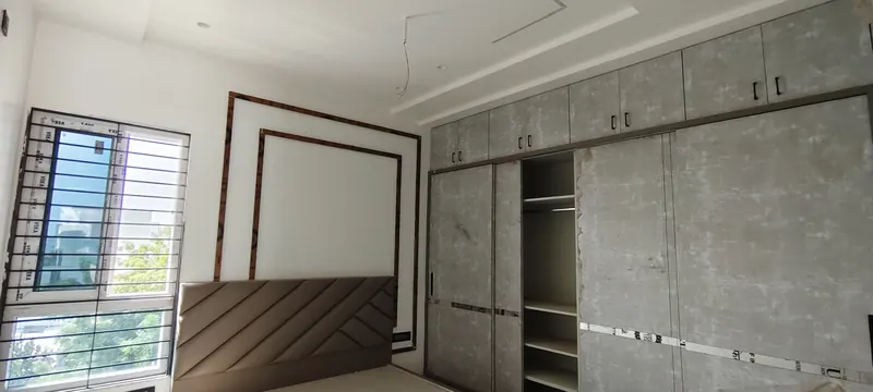Room with wall panelling, wardrobes and a headboard before final finishing