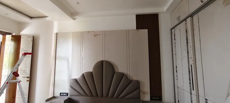 Bedroom with wall panelling, headboard and wardrobes before final finishing