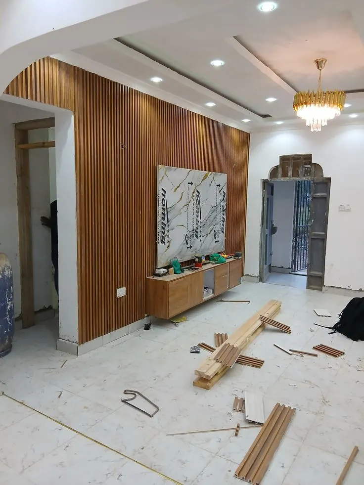 Wood-effect slatted wall panels in a room during installation