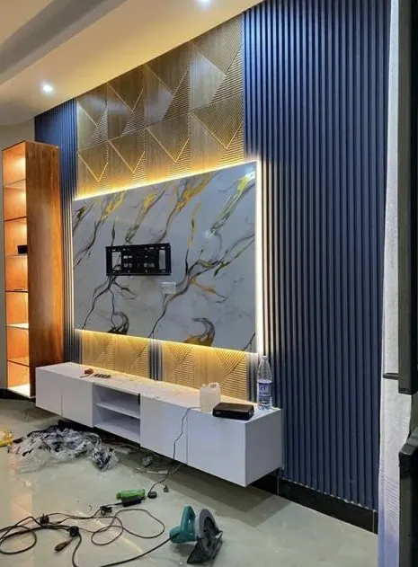 TV wall with a marble-effect panel, blue fluted panels and LED strip lighting
