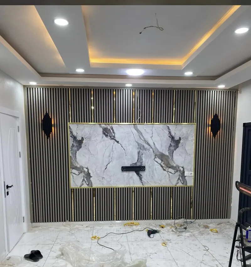Fluted wall panelling with a marble-effect panel and a gypsum ceiling with cove lighting