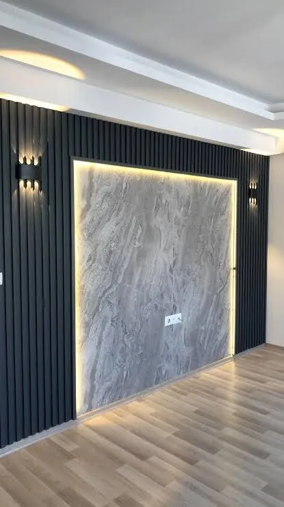 Dark fluted wall panels with a lit marble-effect panel