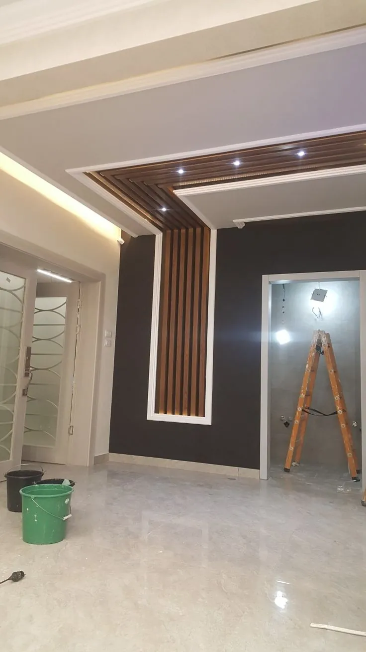 Dark wall with a wood-slat feature strip running up into the ceiling