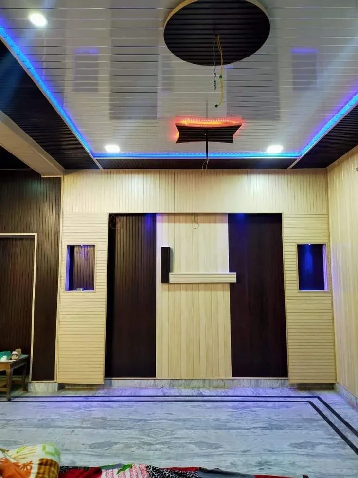 Wood-effect and dark wall panels with a lit ceiling border in a hall