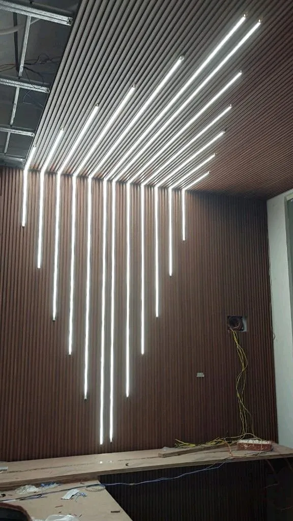 Wood-effect slatted wall and ceiling with LED light lines in a V pattern