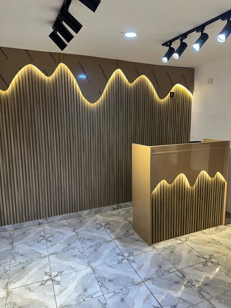 Wood-effect fluted wall with a wavy LED light line and a matching reception counter